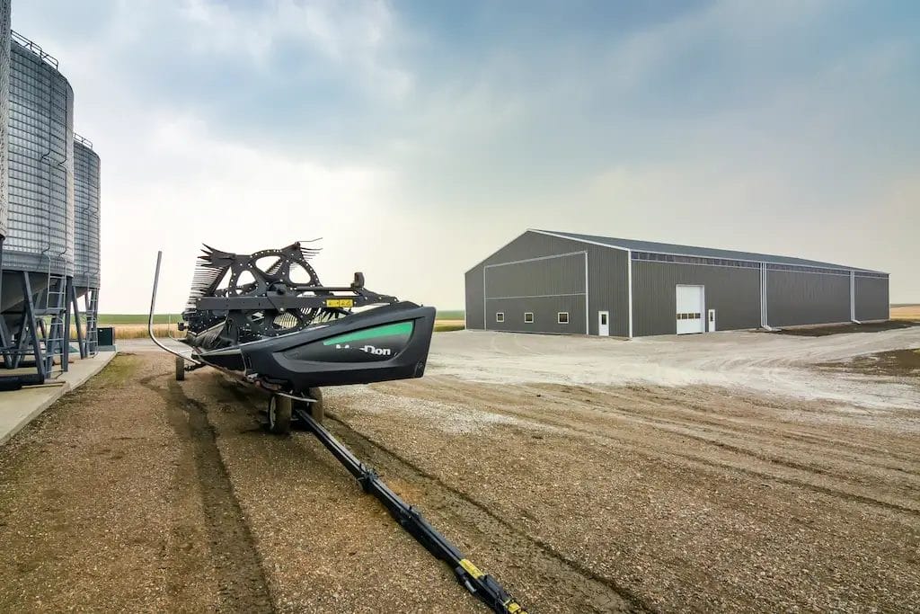 Large equipment cold storage building with grain bins in the foreground