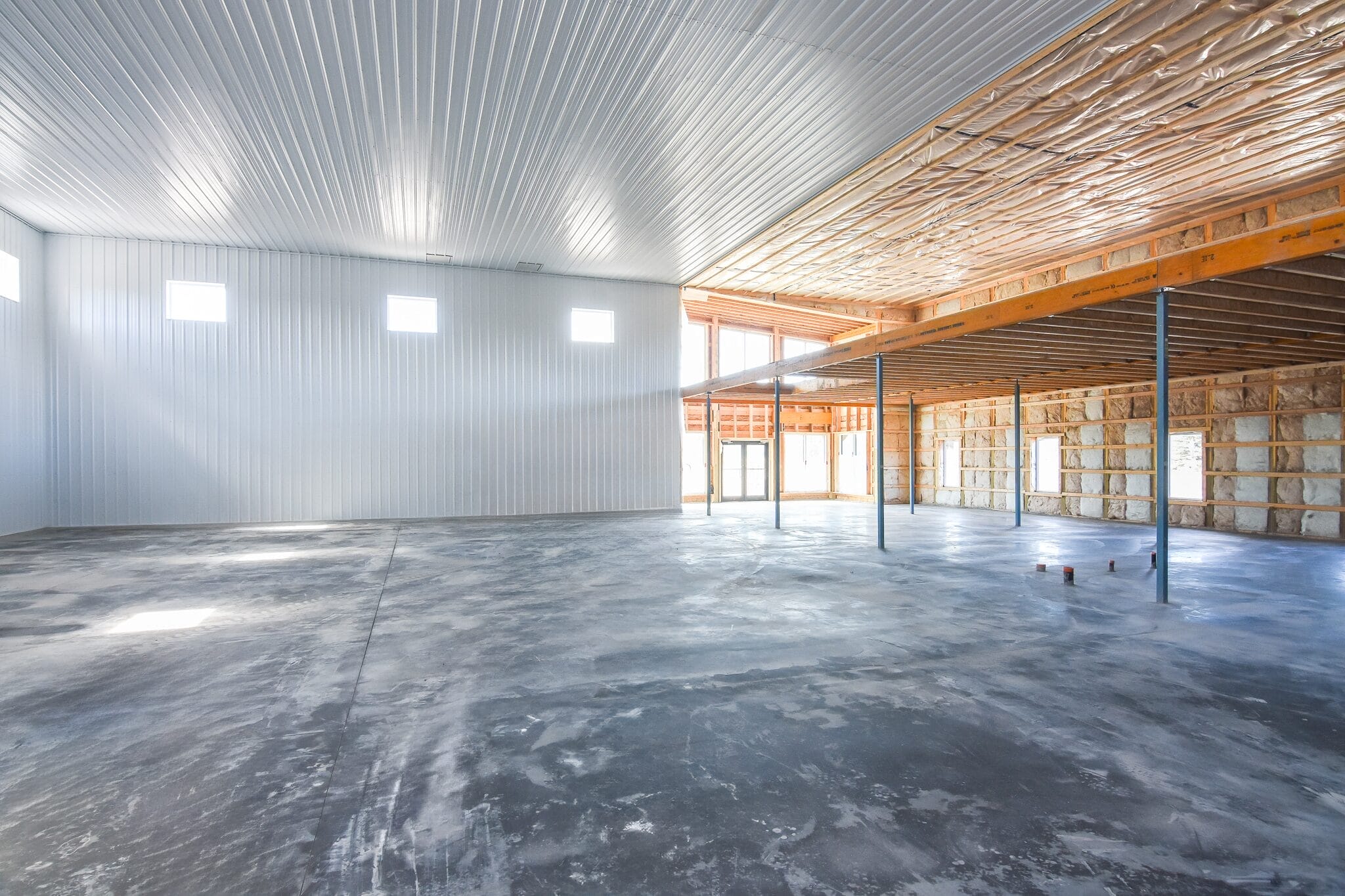 Interior view of a commercial building under construction showcasing exposed framing, and partially finished interior.