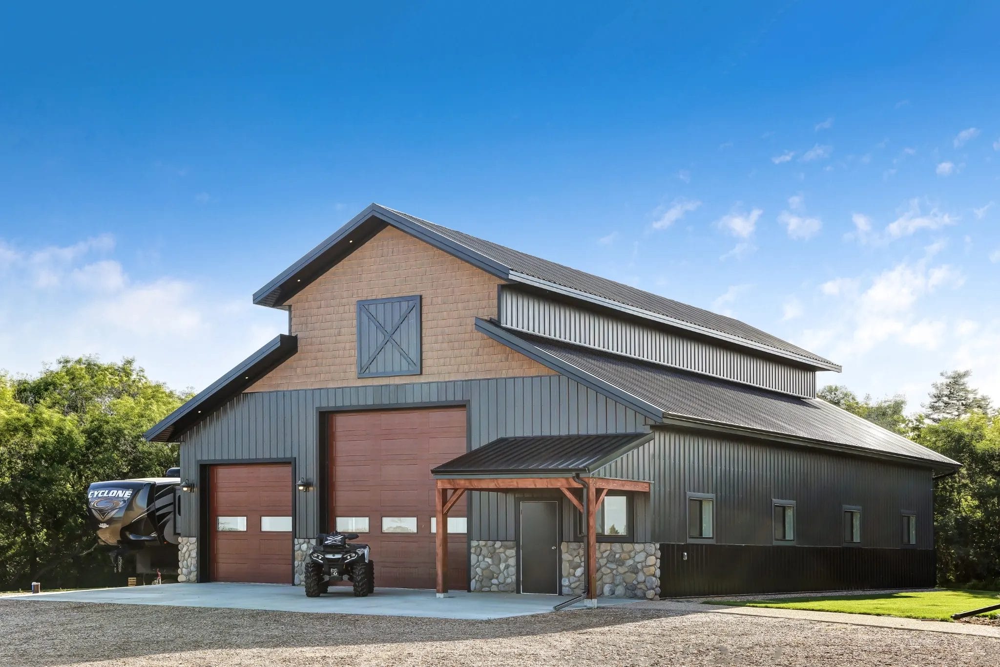 A post frame building with monitor roof and black metal siding.