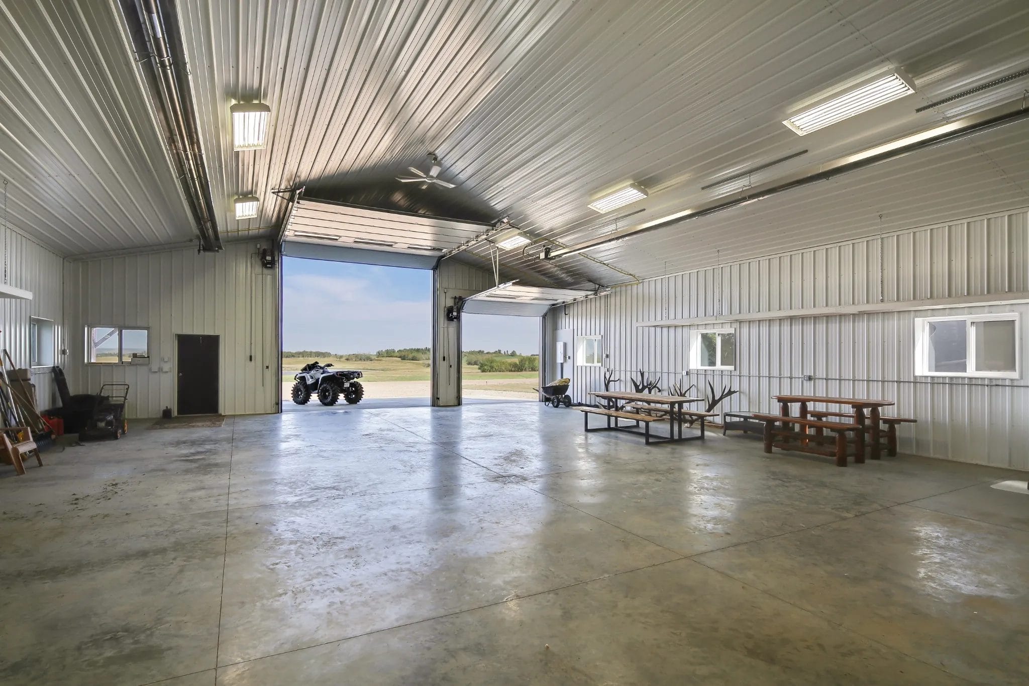 The fully finished interior of an acreage shop looks outward over the scenic countryside.