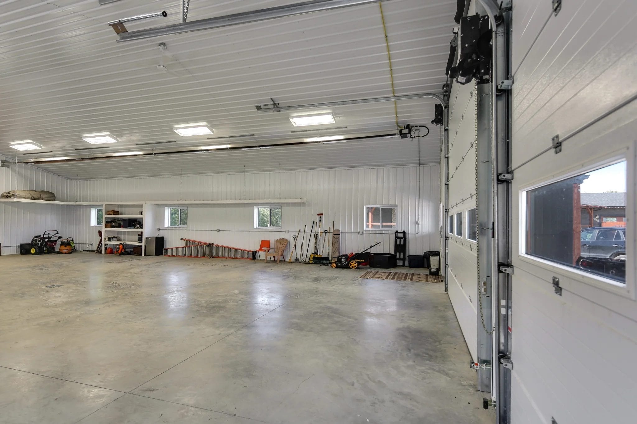 Windows and window panes inside the overhead doors on a acreage shop building with monitor roof creates a bright interior.
