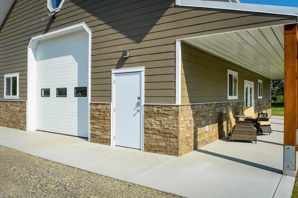 Close up of a detached single car garage with stone wainscoting
