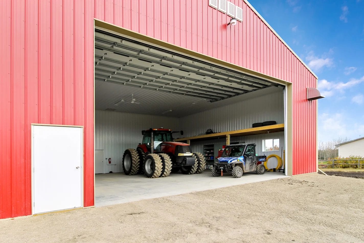 Farm machinery inside a red pole barn shop