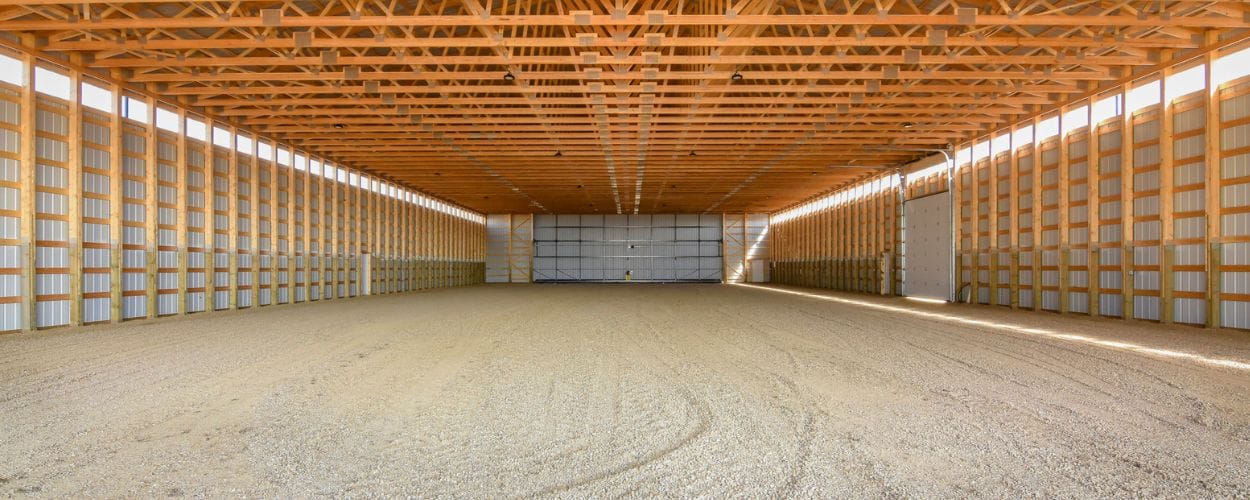 The interior of an unfinished farm building created using post frame construction