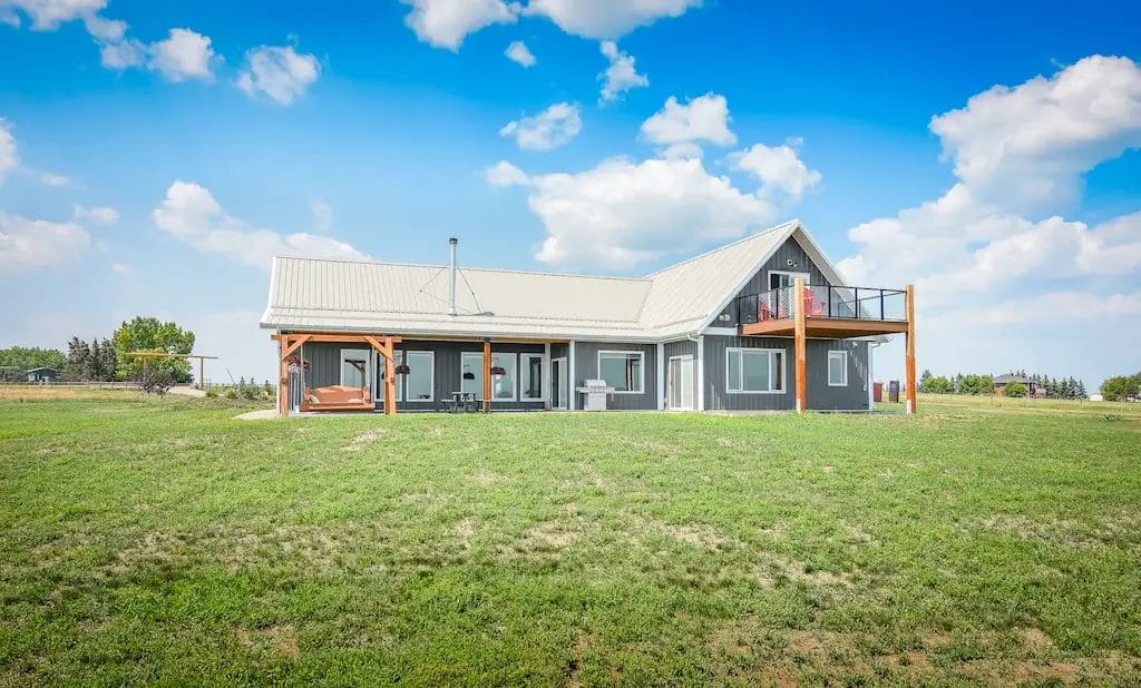 Post frame shop home with multiple outdoor living spaces, porches, and decks attached