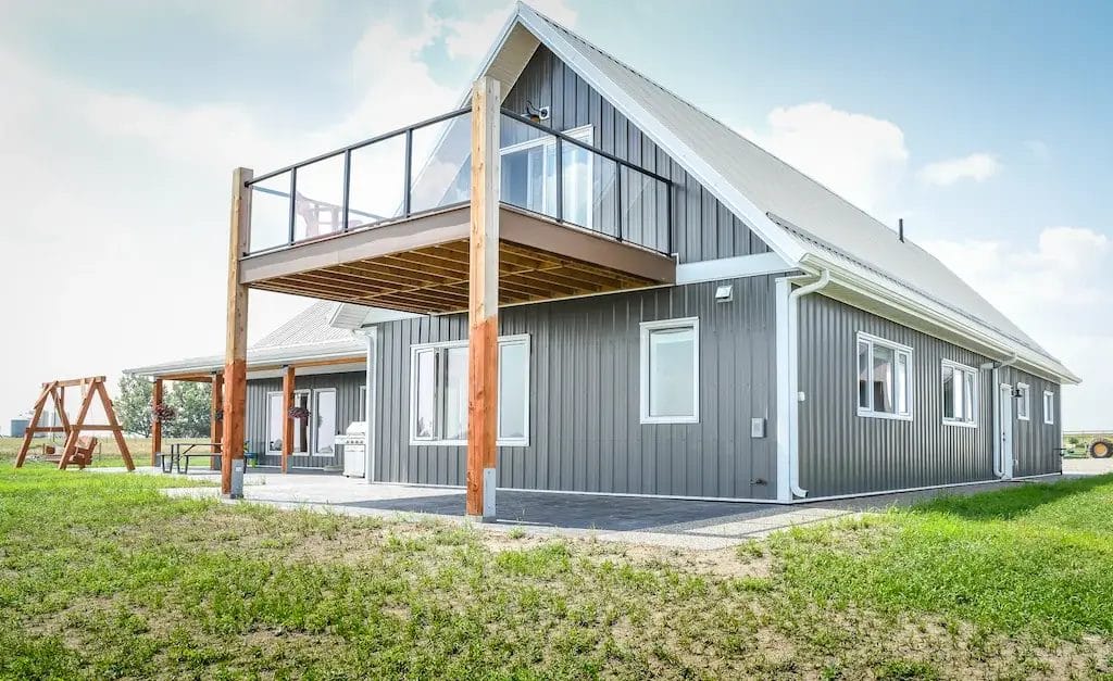Deck on the second floor of a barndominium with a loft above the garage provides views