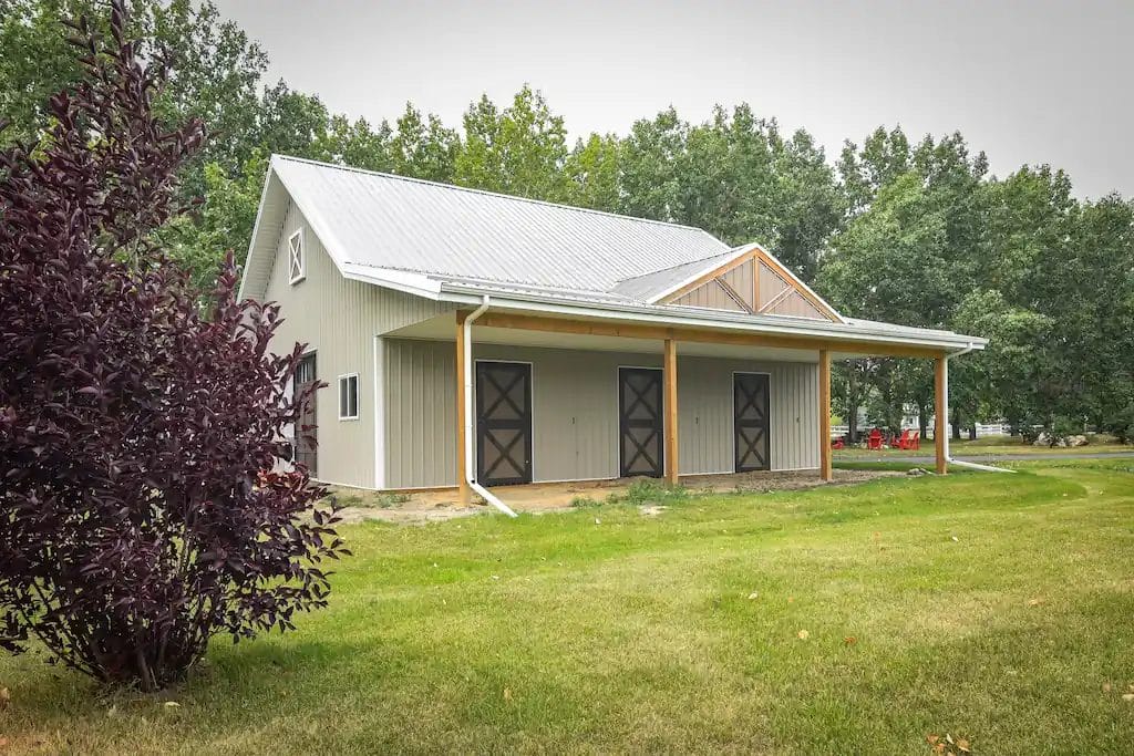 Small pole barn for horses with a lean-to and three Dutch doors