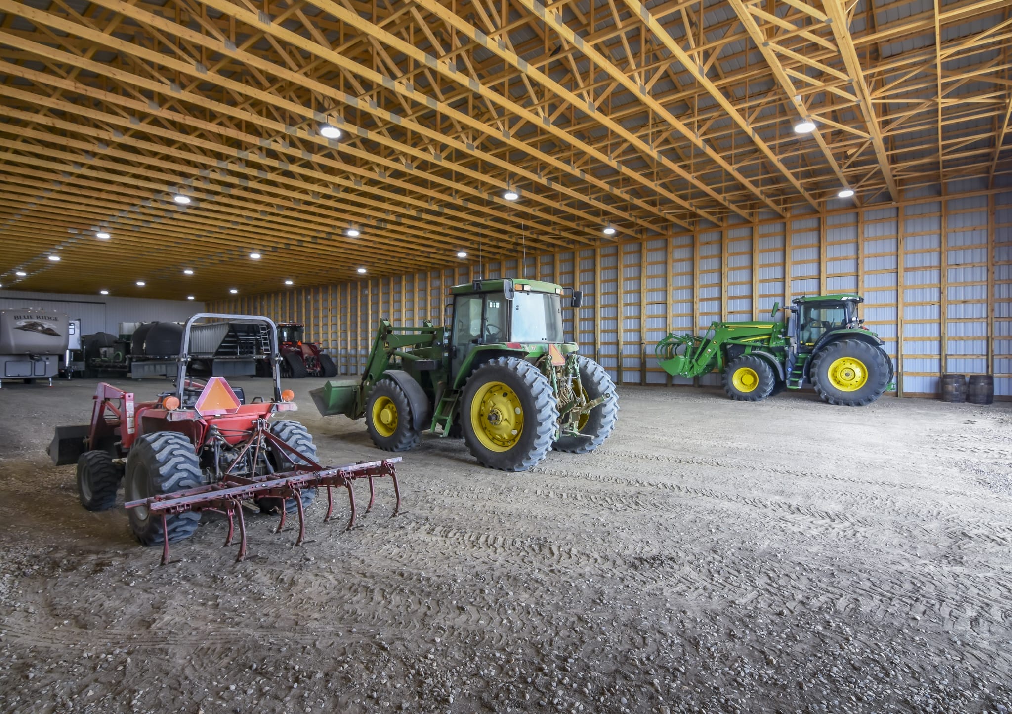 Inside a farm machine shed that has posts spaced closely together for optimum strength