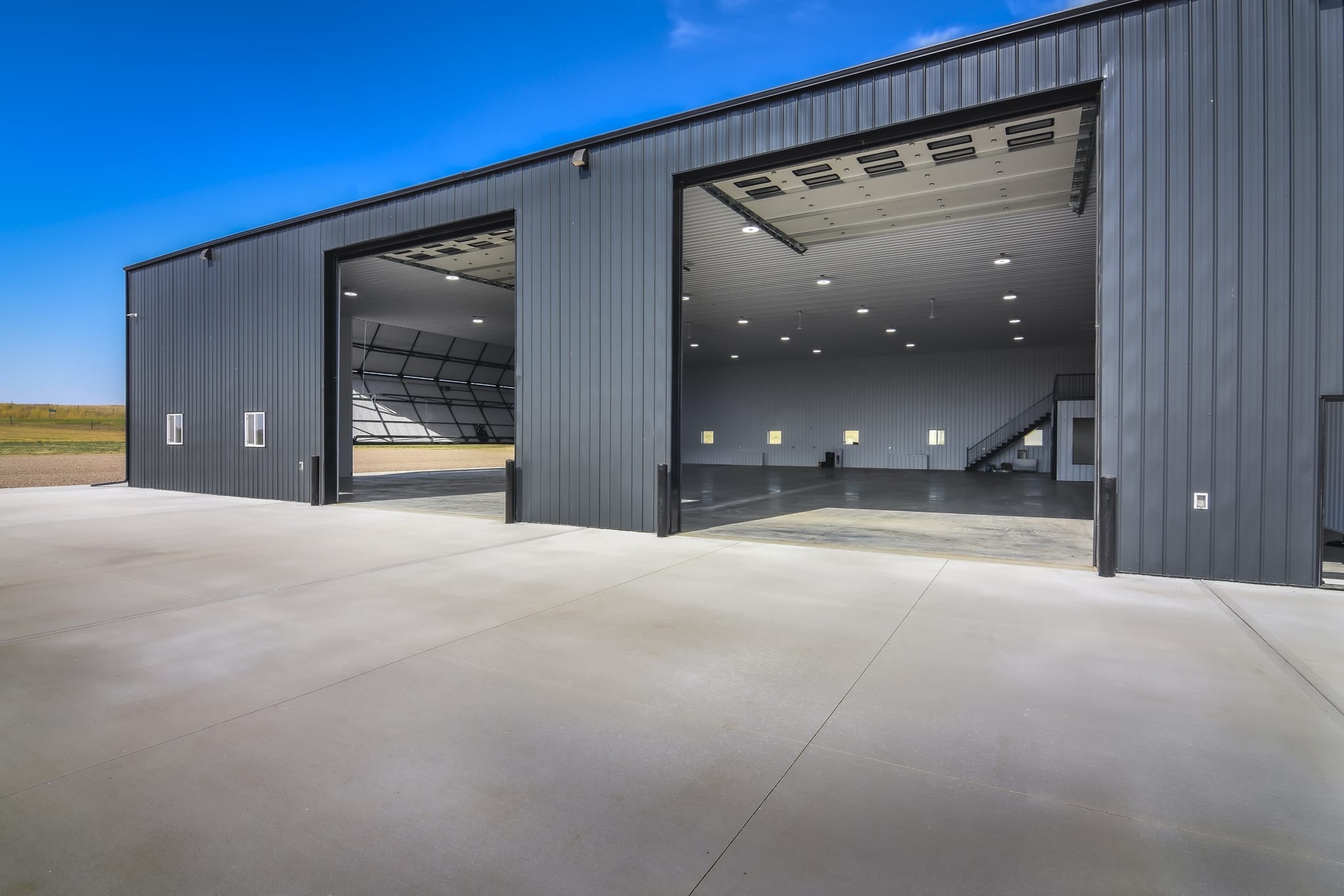 A farm workshop with two overhead doors opened, showing the access points of the building.