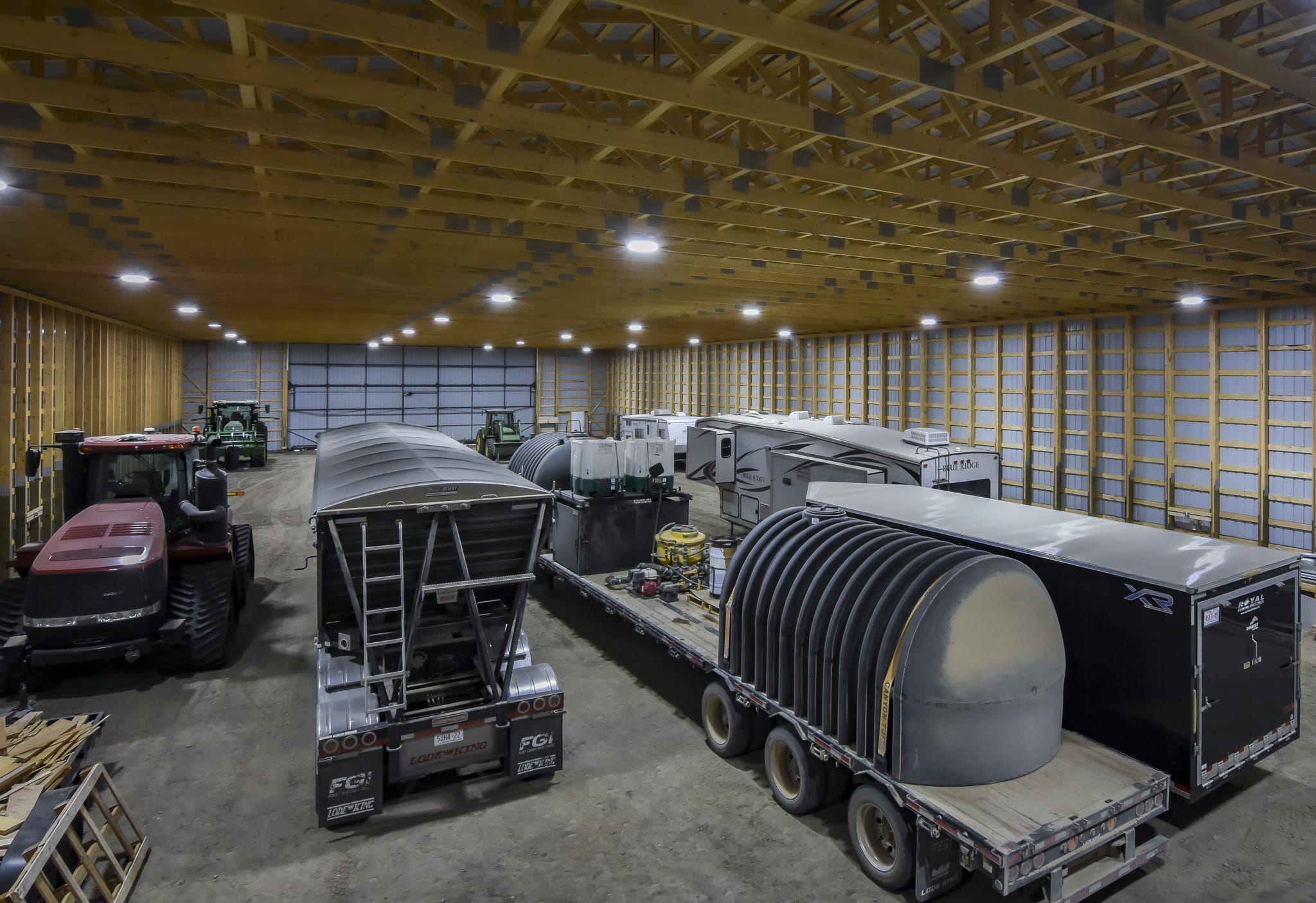 Filled with farm equipment, the machine shed shows a clear-span interior.