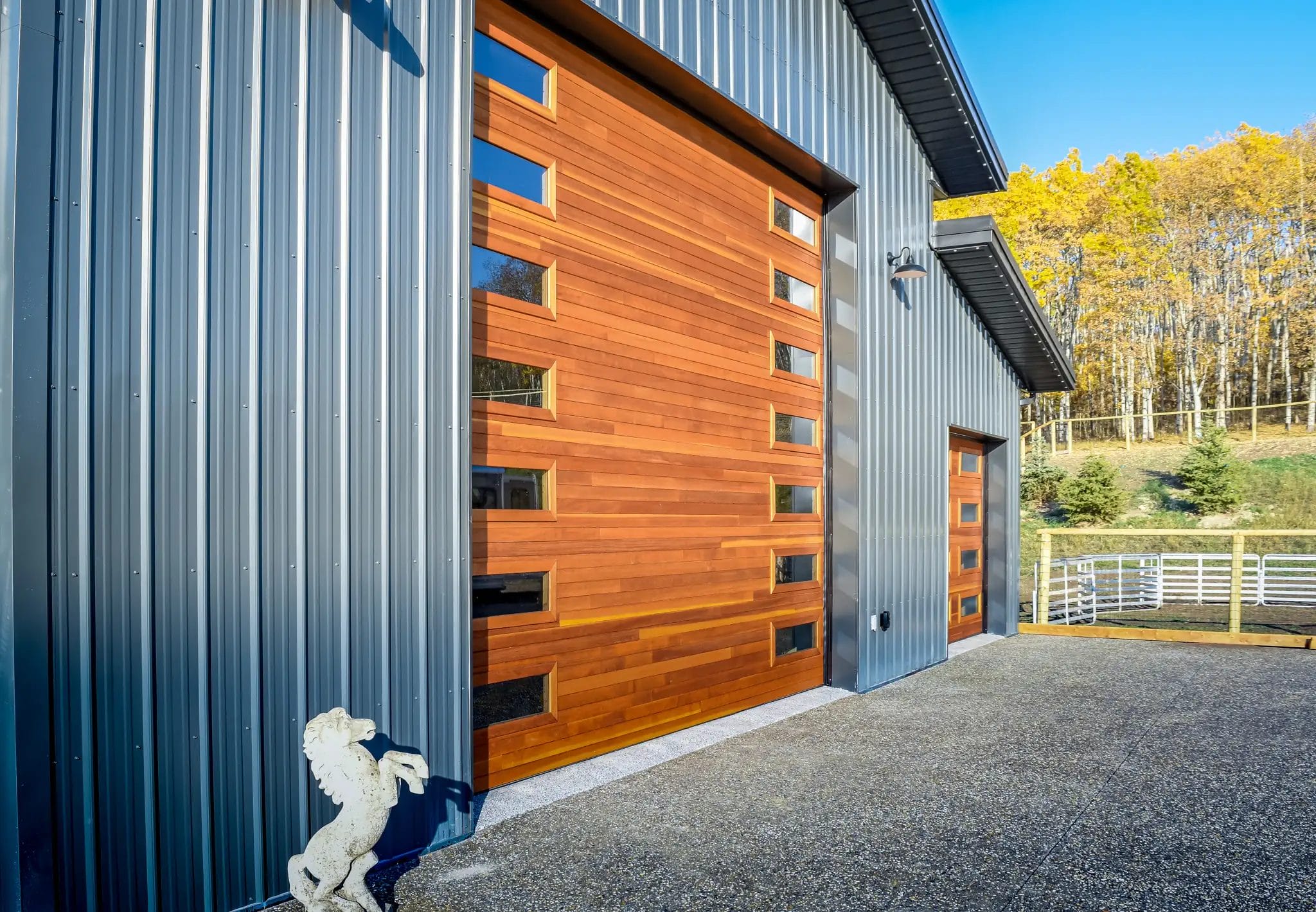 Wood-tone overhead doors on a barndominium with attached garage,