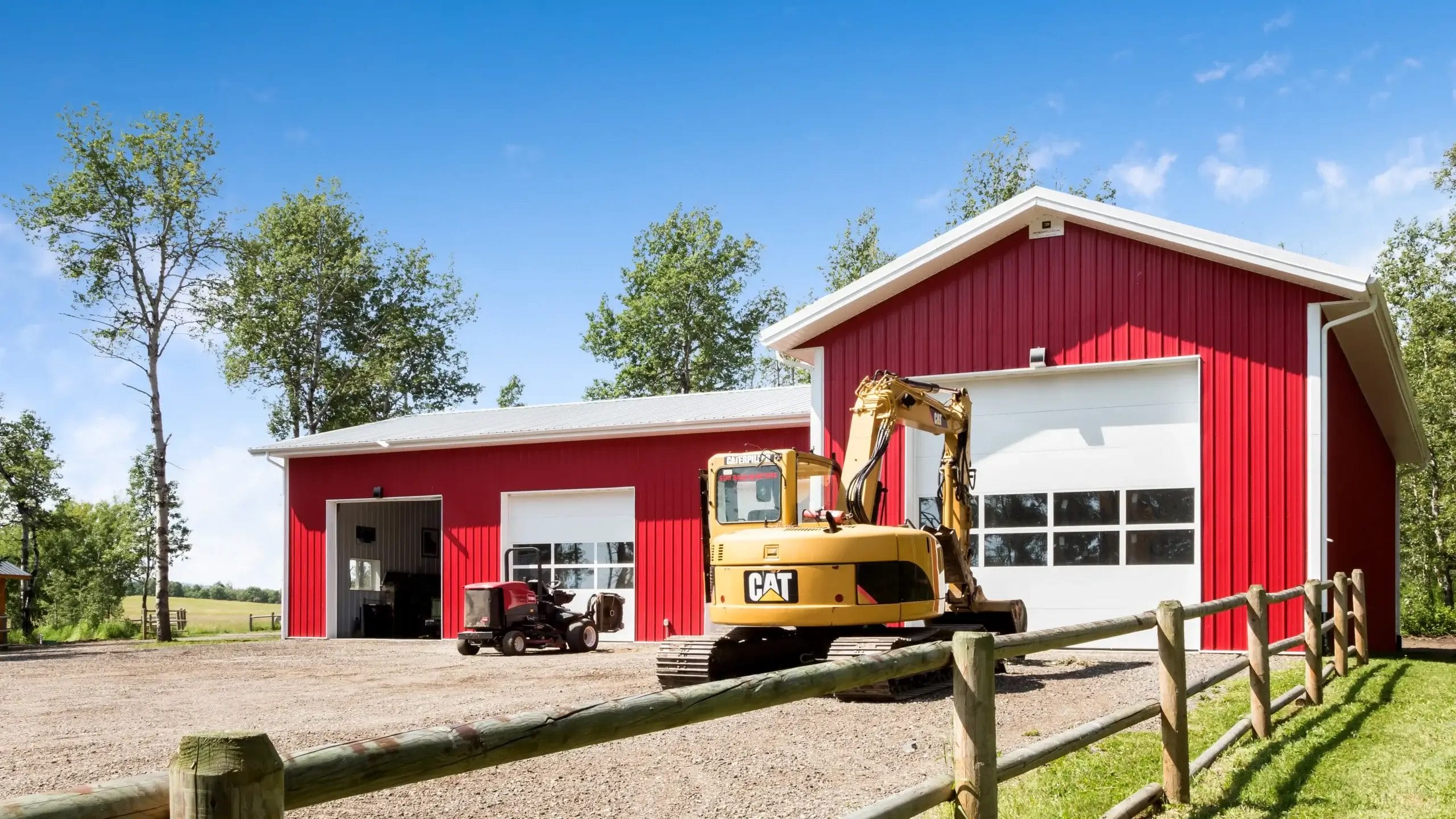 Red and white L shaped garage with 4 bay layout on a rural property.