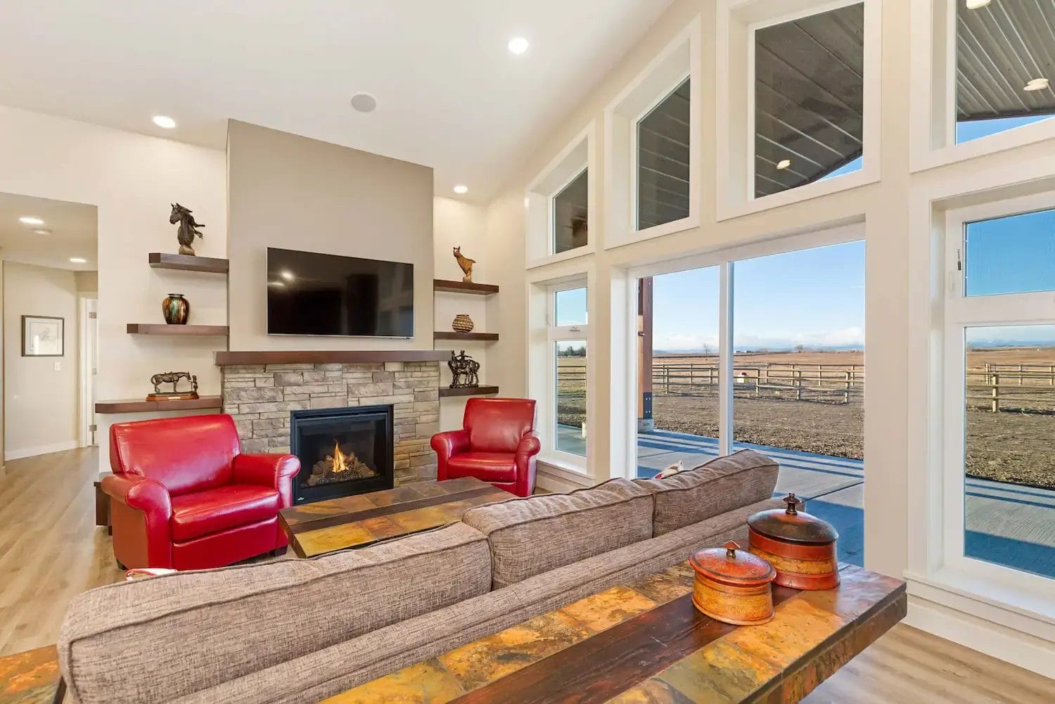 Large windows in a post frame barndominium offer mountain views in Alberta
