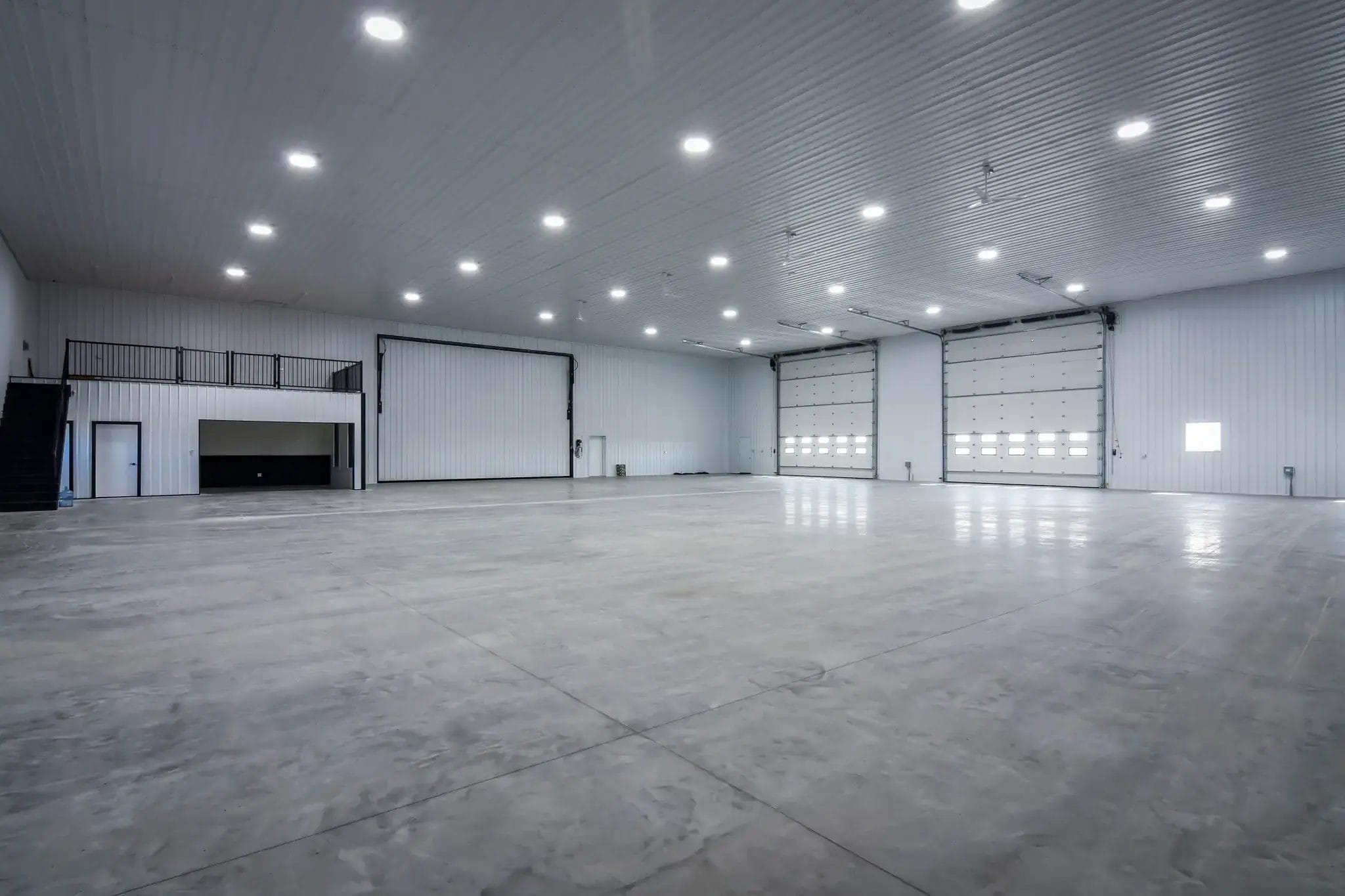 Heated farm equipment workshop, finished with concrete floor, mezzanines, and windows for natural light