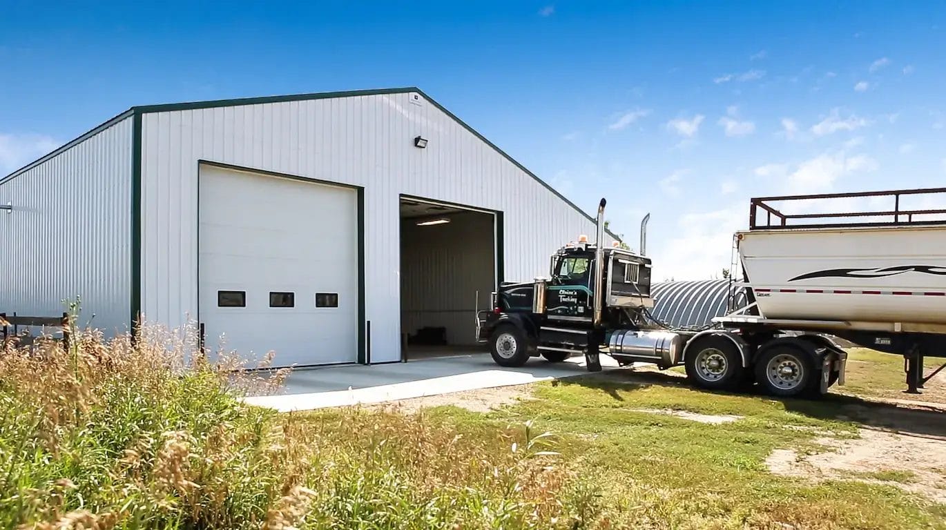 Heated farm shop building exterior with truck and trailer parked in front