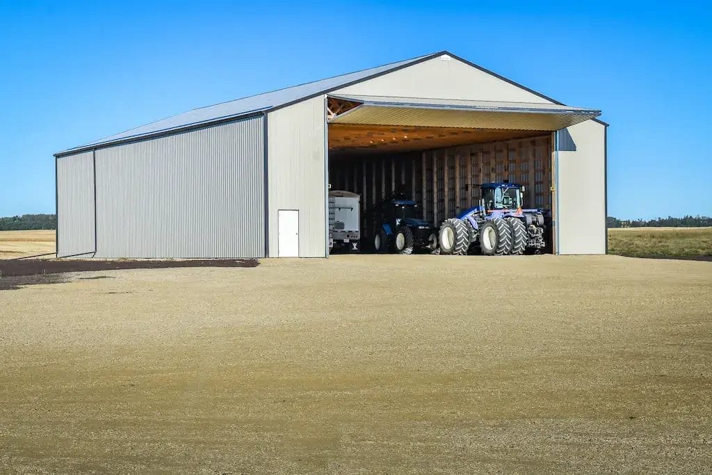 Large post frame machine shed being used as cold storage for farm equipment