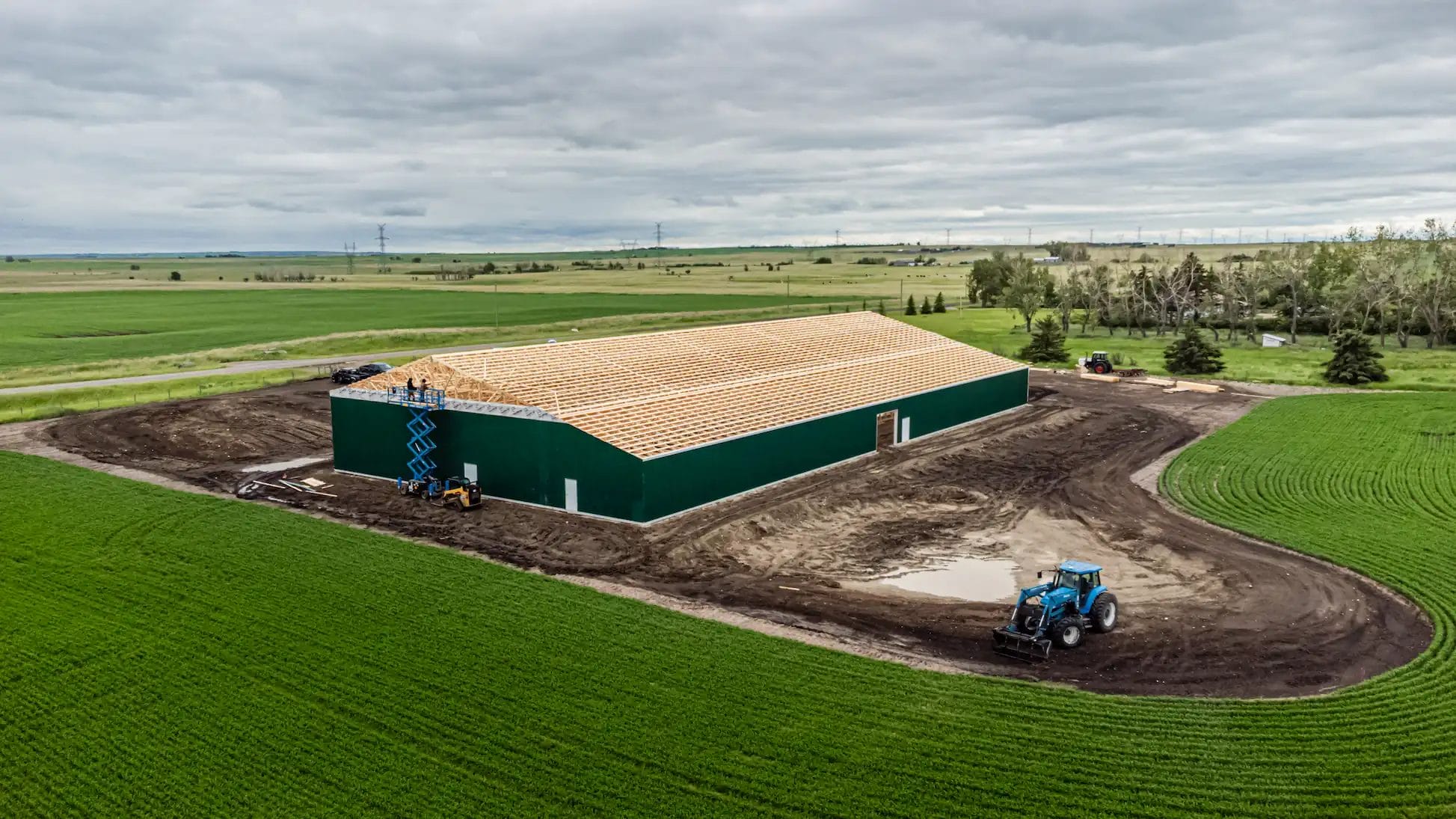 Post frame builders working on a pole barn on a Western Canada rural property