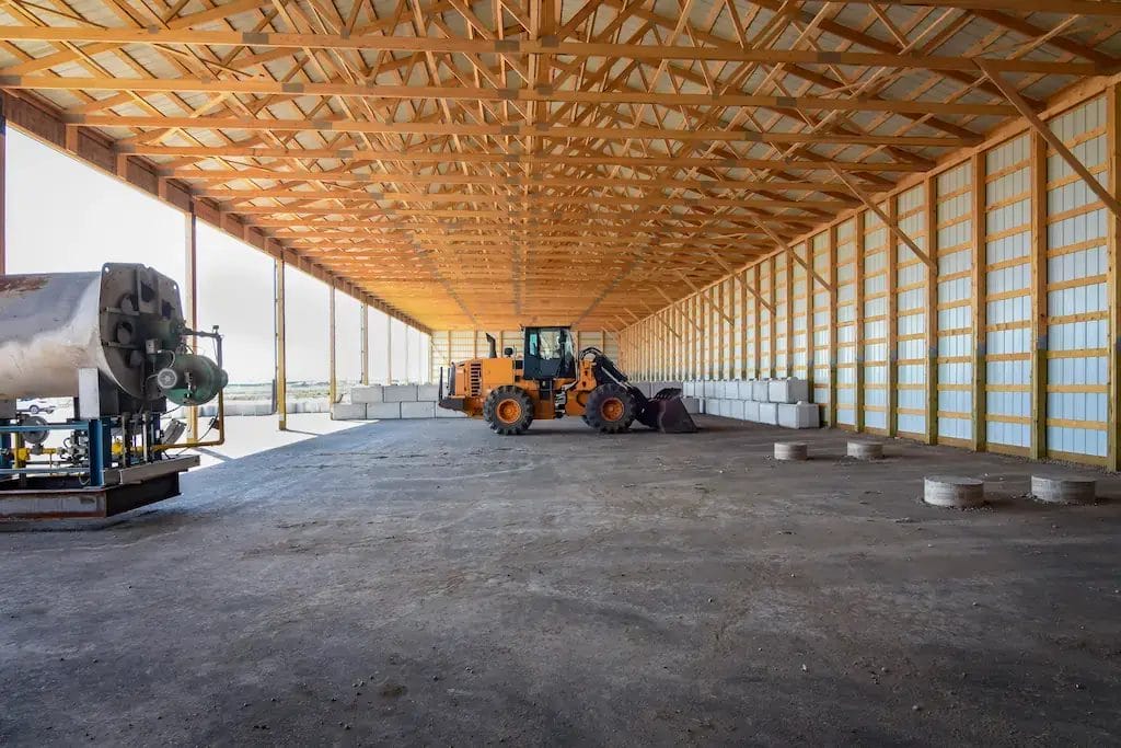 Pole hay barn with machinery parked inside